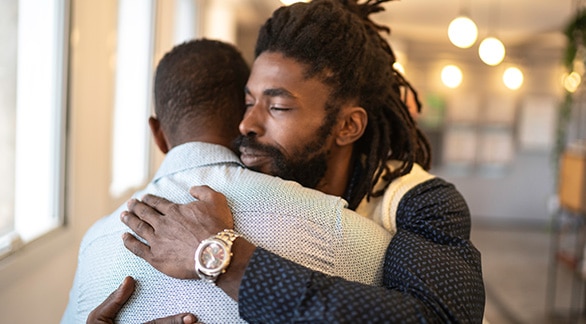 Dos personas reconfortándose mutuamente