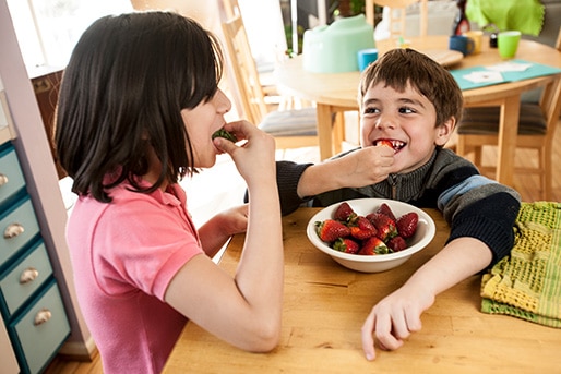 Dos niños comen fresas