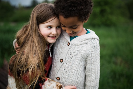 Two children smiling and hugging