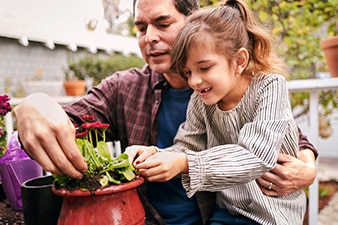 Persona e hija plantando una planta