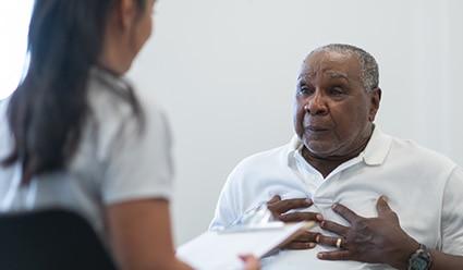 Persona describiéndole sus síntomas a un profesional clínico de salud