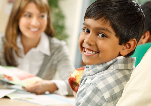 Child smiles at kitchen table Child smiles at kitchen table