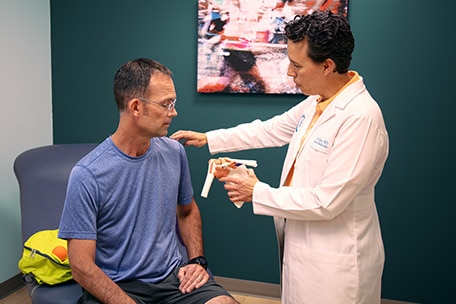 Médico examinando el hombro de un paciente 