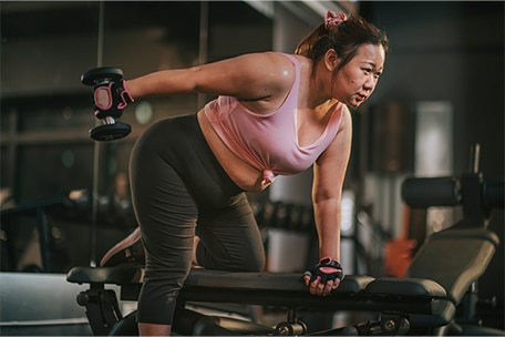 Persona haciendo entrenamiento de fuerza con pesas en el gimnasio