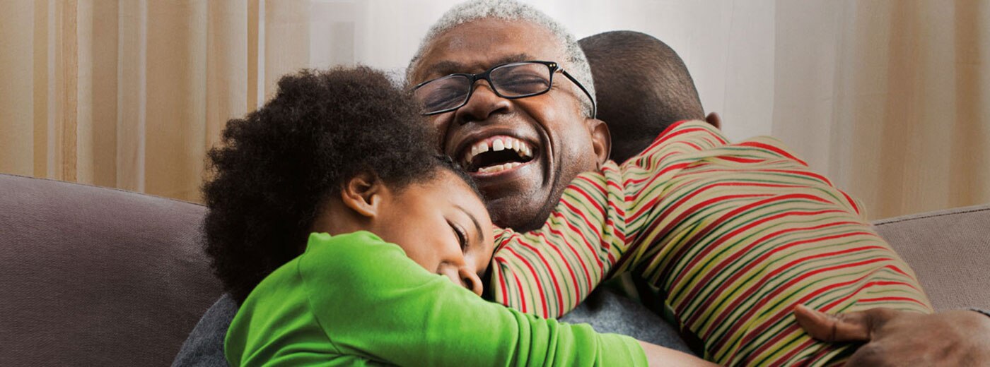 Photo of old man hugging two children Photo of old man hugging two children