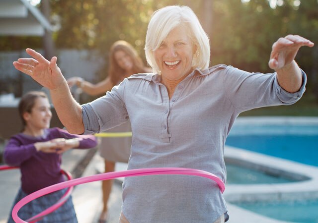 Fotografía de una mujer y niños con un aro hula-hula junto a la piscina