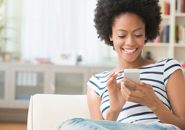 Fotografía de una señora usando un teléfono inteligente en el sillón Fotografía de una señora usando un teléfono inteligente en el sillón