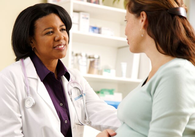 Photo of doctor sitting beside pregnant woman Photo of doctor sitting beside pregnant woman