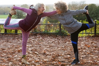 Dos amigas haciendo ejercicios de estiramiento al aire libre