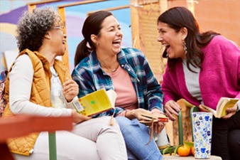 Grupo de amigas riendo en un club de lectura