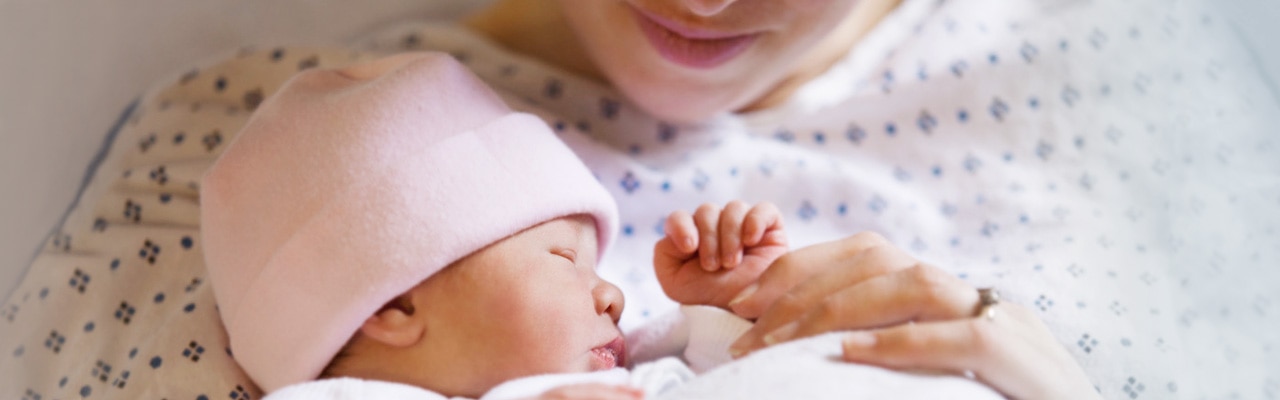 close up of a woman holding a newborn baby