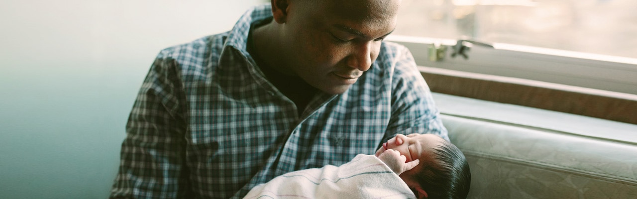 man holds newborn