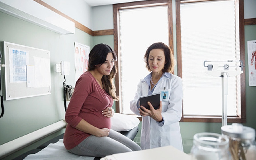 nurse-midwife reviewing medical chart with patient