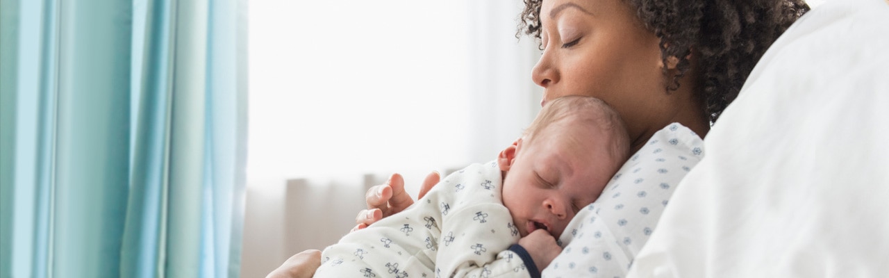 Sleeping mother and newborn baby in a hospital bed