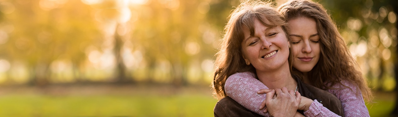 Mujer que abraza a su amiga sonriente