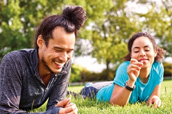 Una pareja tendida en el césped y riendo