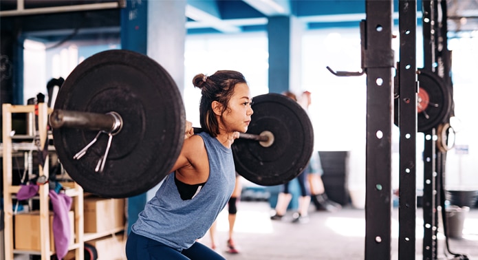 Person lifting weights in a gym (en inglés)