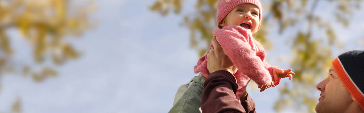 Dad holding smiling young baby