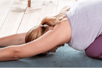 Una persona tomando una clase de yoga en casa con la computadora portátil