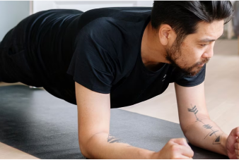 Una persona en posición de plancha sobre un tapete de yoga