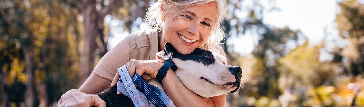 Mujer feliz que abraza a su perro