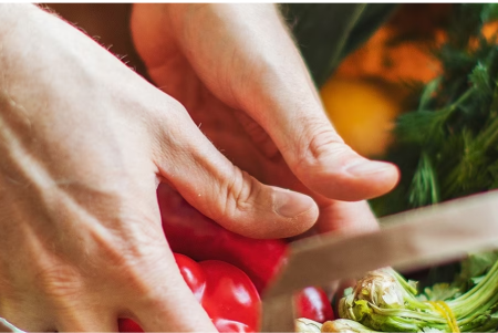 Una mujer sostiene un tazón de verduras recién cortadas