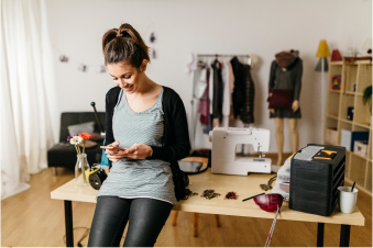 Mujer joven que mira su teléfono y sonríe