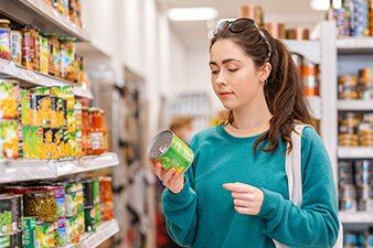 Una persona leyendo la etiqueta de un alimento enlatado