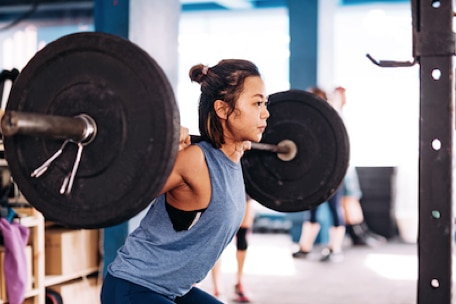 Person lifting weights in a gym (en inglés)