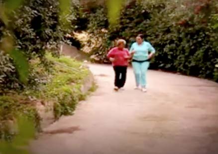 two woman power walk down road