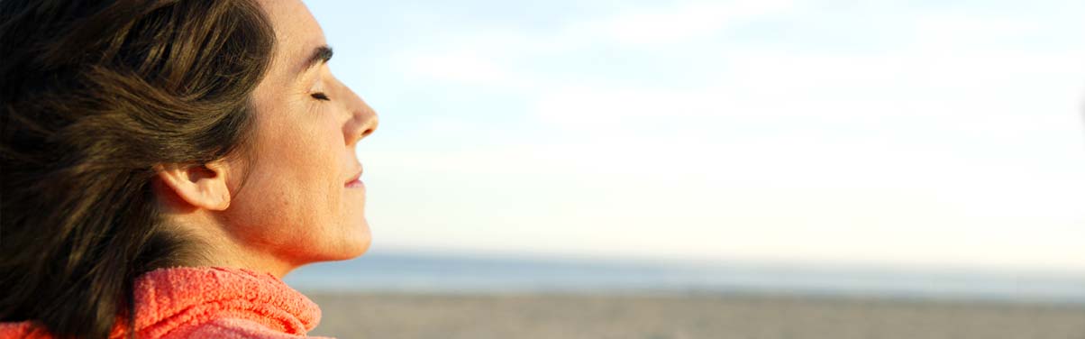 Woman at the beach with her eyes closed