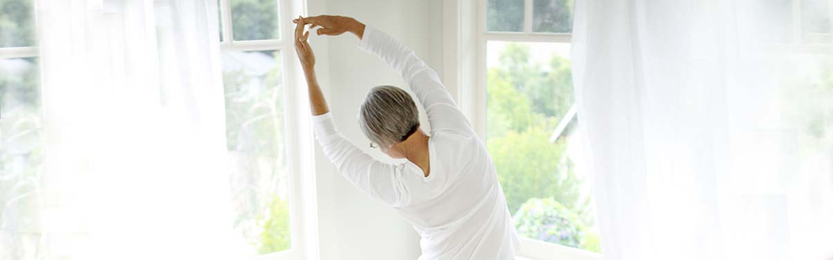 Woman stretching by windows