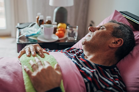 Persona enferma durmiendo en una cama