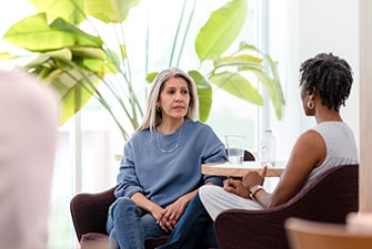 Dos personas sentadas a la mesa charlando 