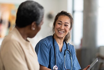 Médico sonriente que habla con su paciente