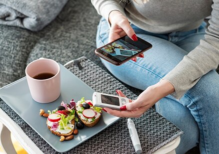 una mujer usando su teléfono celular para buscar información sobre los alimentos