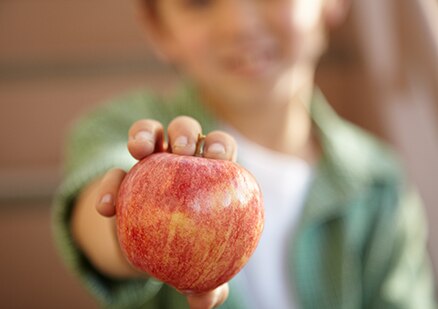 un niño sosteniendo una manzana