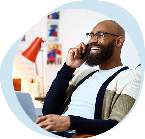 Hombre sonriente con anteojos y barba que toma clases de bienestar por teléfono