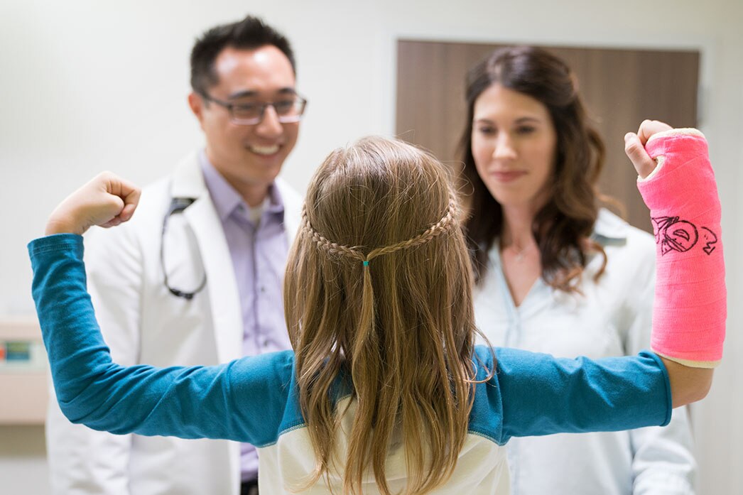Child posing with cast for doctors