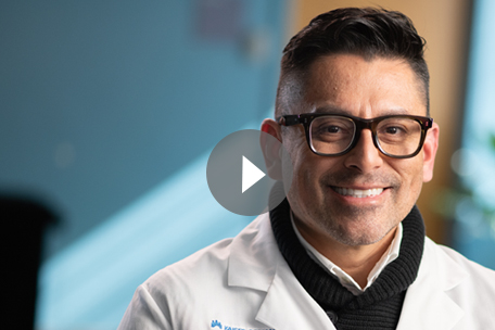 Video play button over image of Kaiser Permanente Colorado doctor smiling