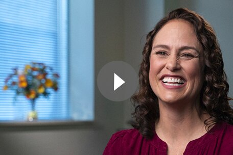 Video play button over image of Kaiser Permanente Colorado member smiling