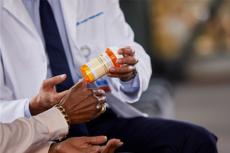 Médico con un frasco de medicamentos en la mano