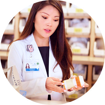 Farmacéutica preparando un frasco de medicamentos.
