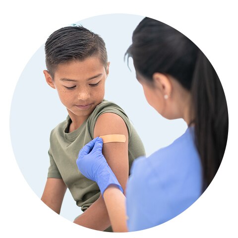 Enfermero aplicando una curita en el brazo de un niño
