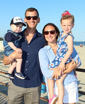 Mother and father with their 2 children on a beach.