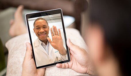Persona haciendo una consulta virtual con su médico en una tableta