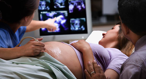 Médico y paciente revisando un ultrasonido de embarazo