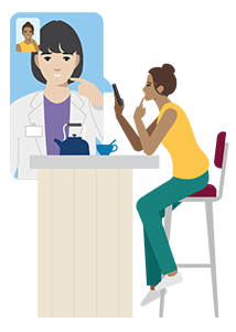 Una persona sentada en un escritorio en videoconsulta con un médico en su teléfono.