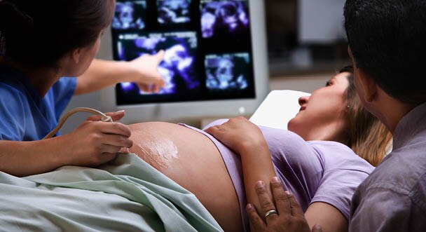 Médico y paciente revisando un ultrasonido de embarazo