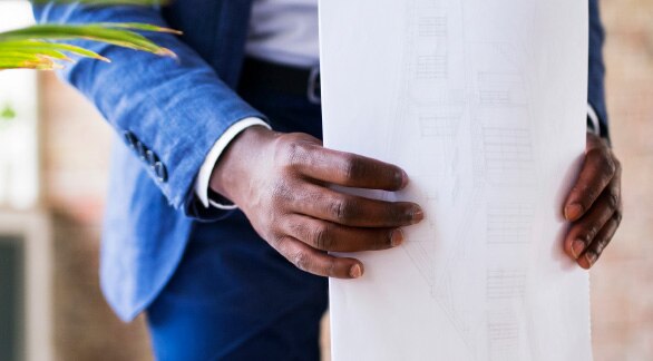 man in suit holds papers